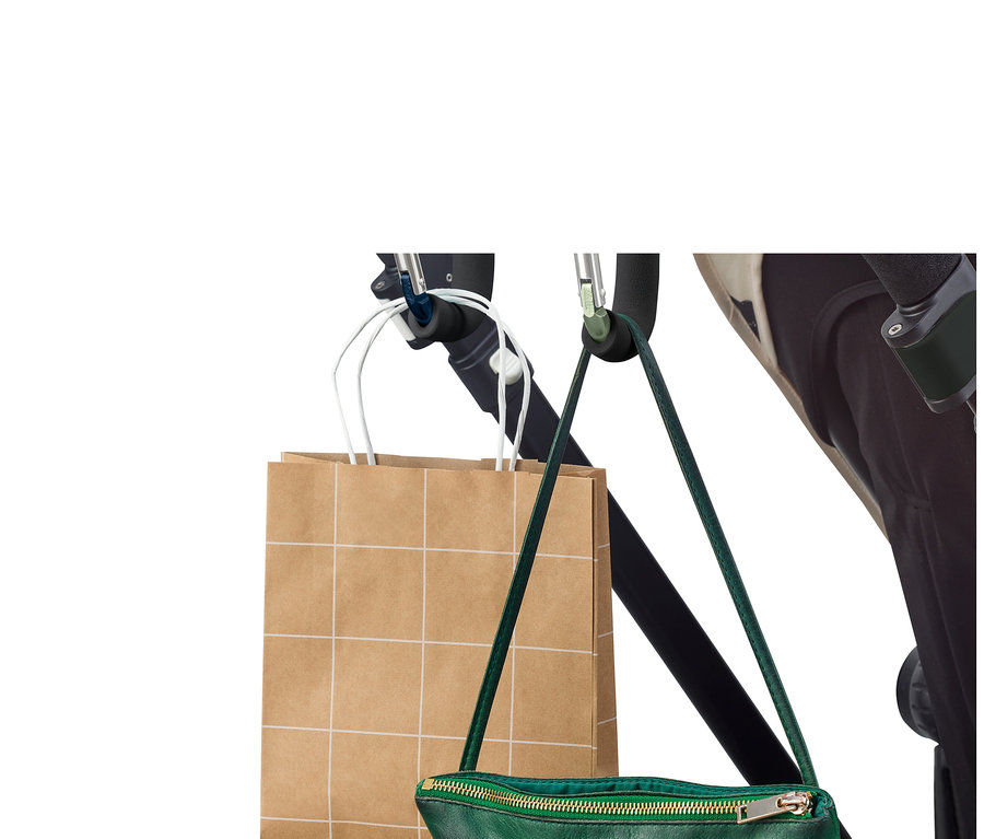 Torba na zakupy i zielona torebka wiszą na wózku za pomocą 2 karabińczyków XXL.