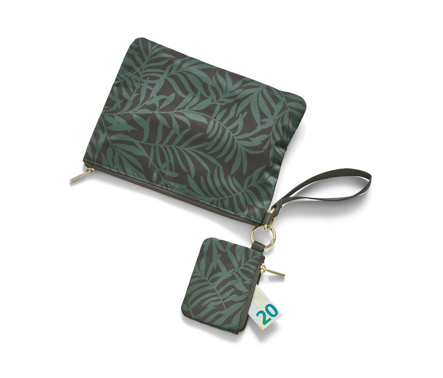 Dwie torebki do przechowywania z motywem liści, jedna leży, a druga wisi z dwudziestoeurowym banknotem w środku.