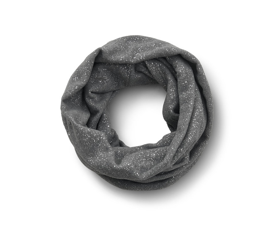 Szary, błyszczący komin z polaru leży złożony na białej powierzchni.