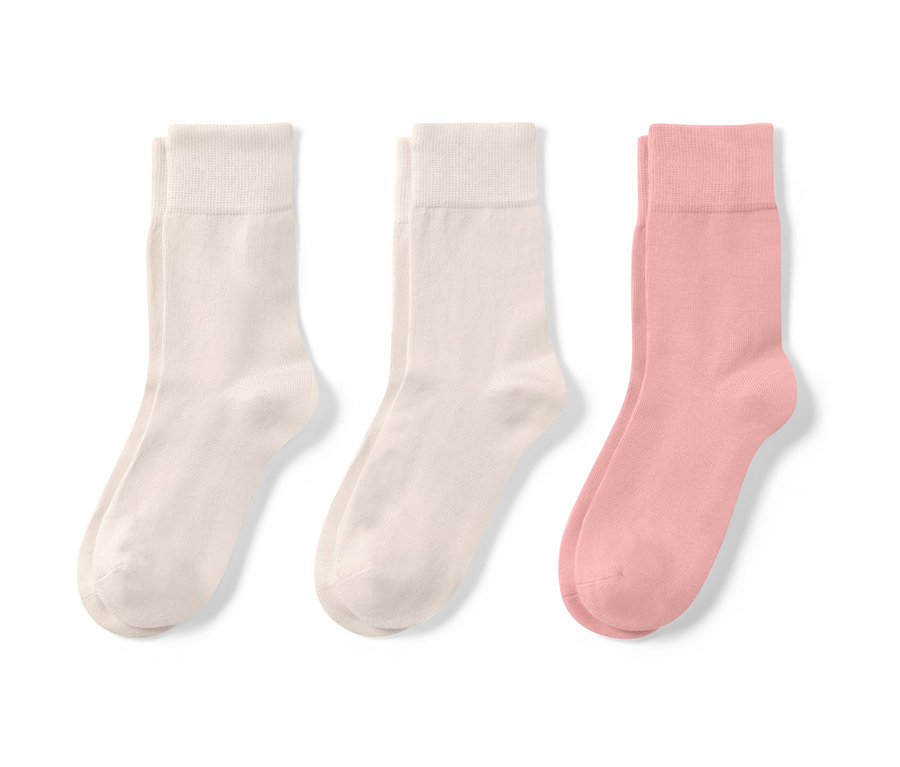 Trzy pary jasnych skarpetek.