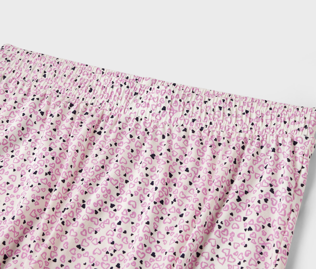 Szczegół damskich spodni z elastyczną talią i nadrukiem drobnych serduszek.