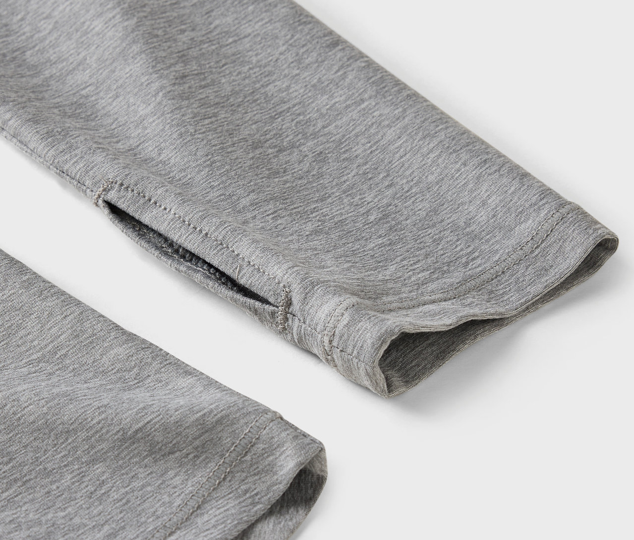 Zbliżenie na szary rękaw z otworem na kciuk.