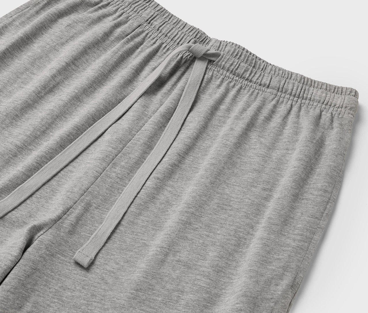 Zbliżenie na szare spodnie dresowe ze ściągaczem w pasie i sznurkiem.