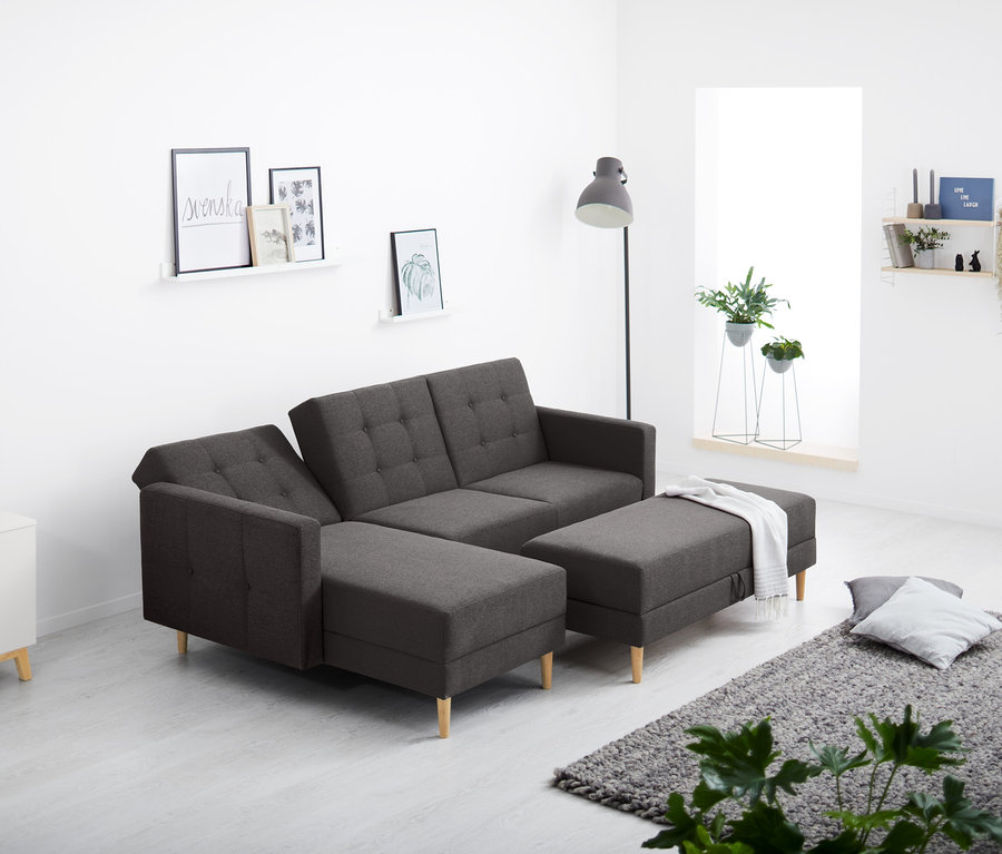 W salonie stoi sofa narożna sprężynowa ze skrzynią.