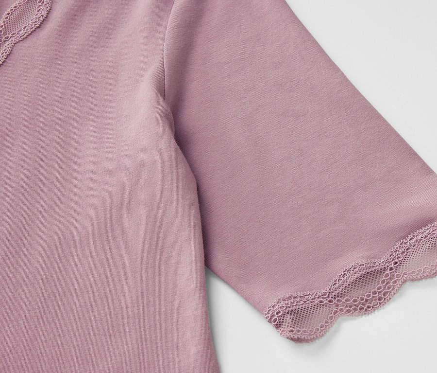 Zbliżenie na fioletową koszulkę z krótkim rękawem i koronkowymi detalami.