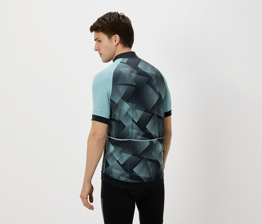 Mężczyzna od tyłu w niebiesko-czarnej koszulce rowerowej i czarnych spodniach na białym tle.