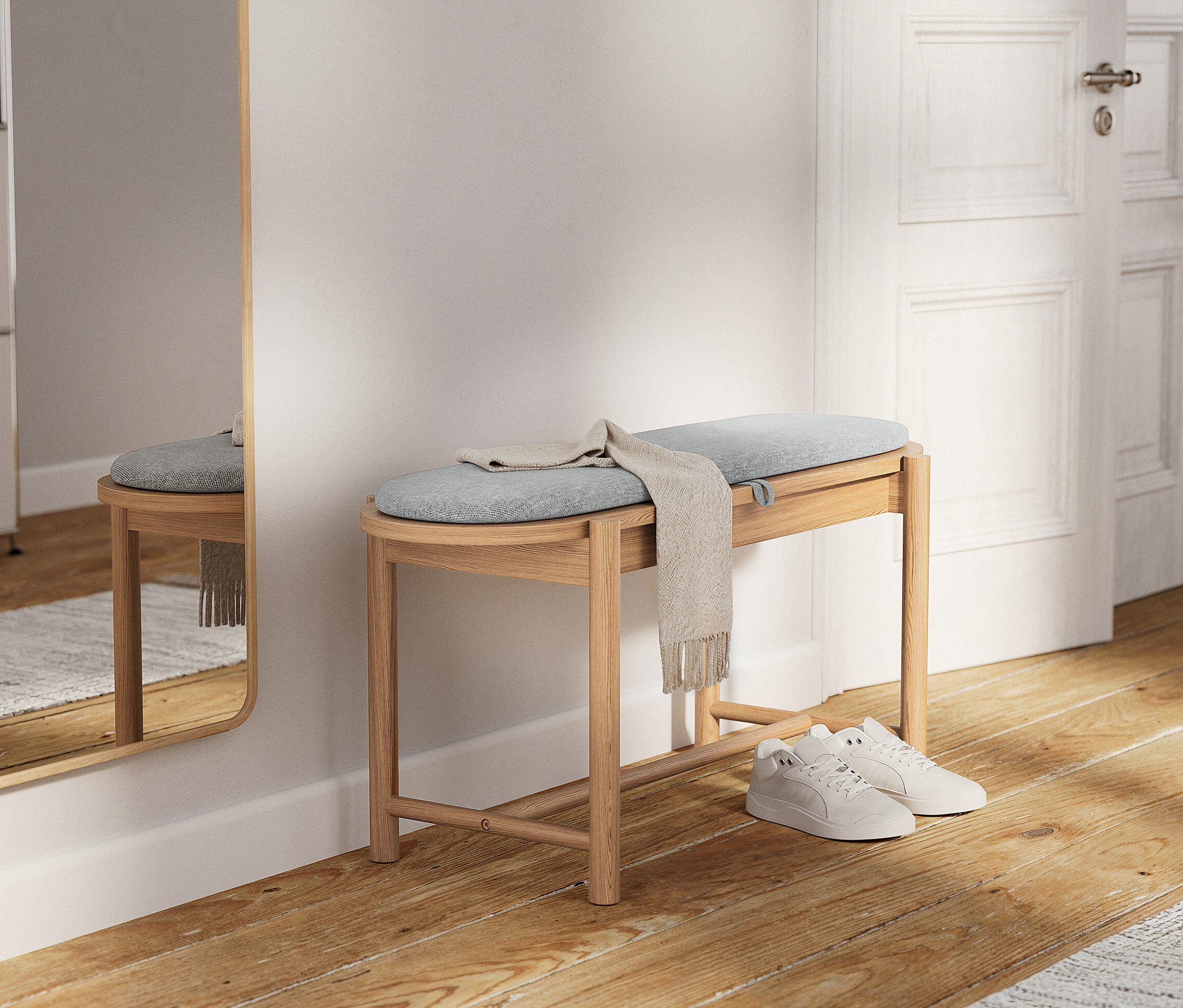 Jasne drewniane siedzisko z jasnoniebieską poduszką i beżowym szalem. Pod spodem leżą białe tenisówki.