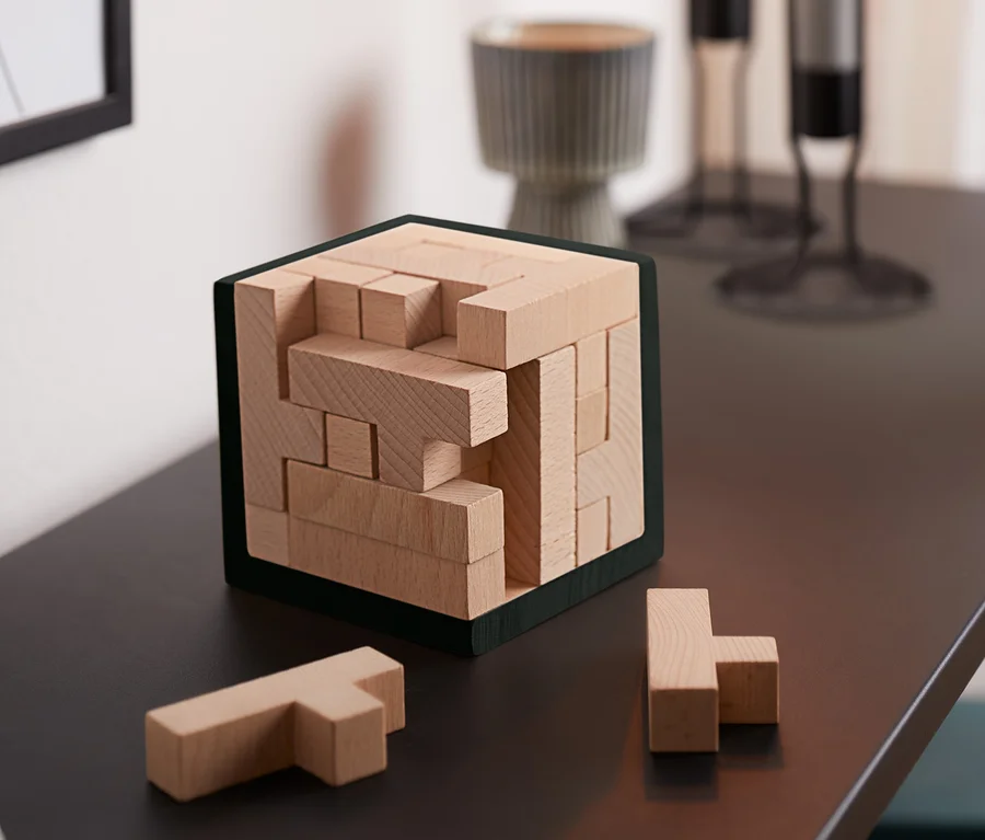 Na stole stoi Puzzle IQ – kostka i dwa elementy obok.