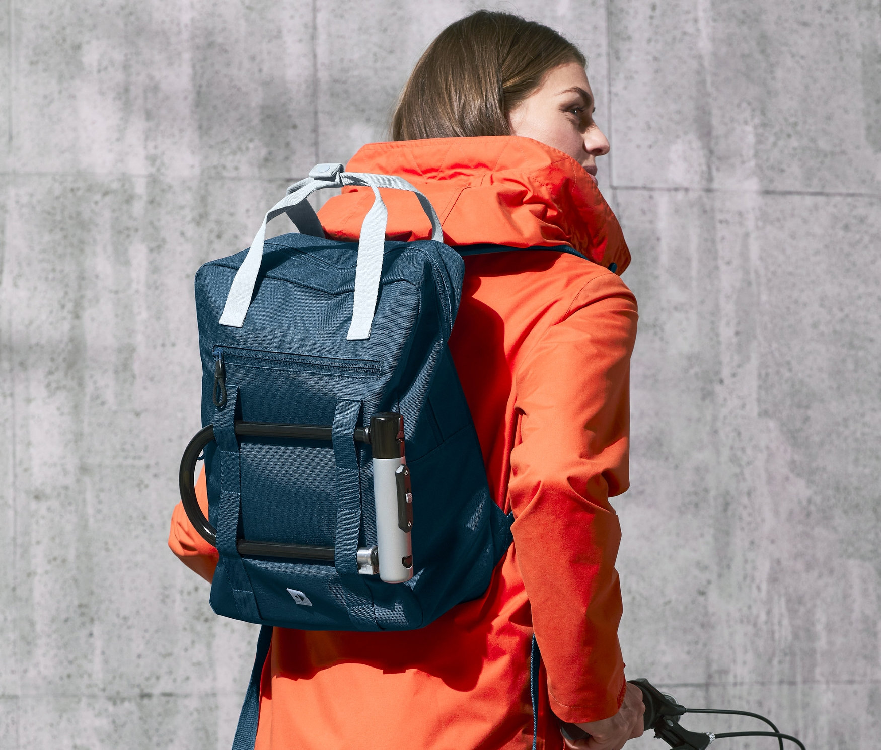 Kobieta z plecakiem outdoorowym na rowerze.