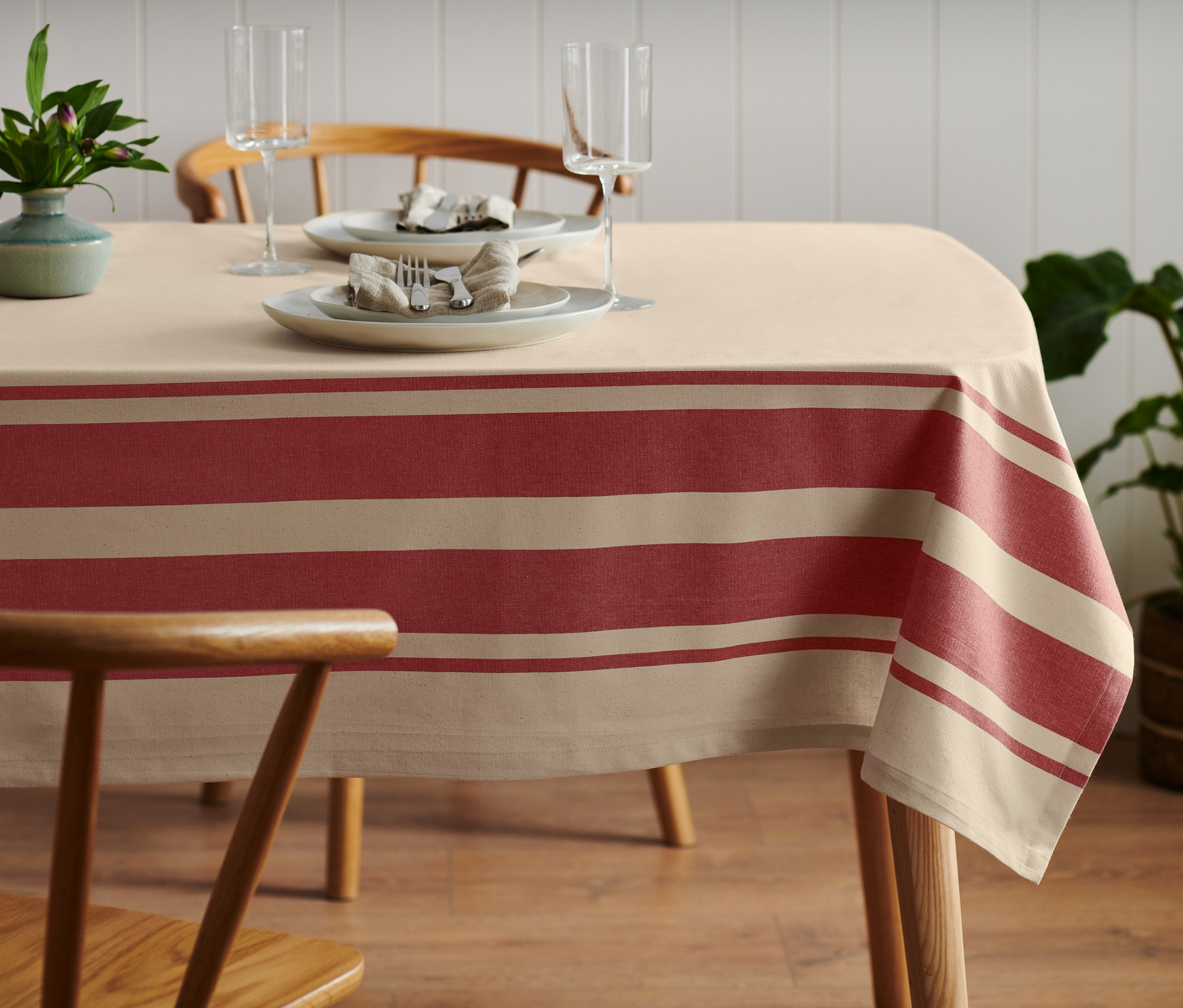 Beżowy obrus w tkane paski na nakrytym stole.