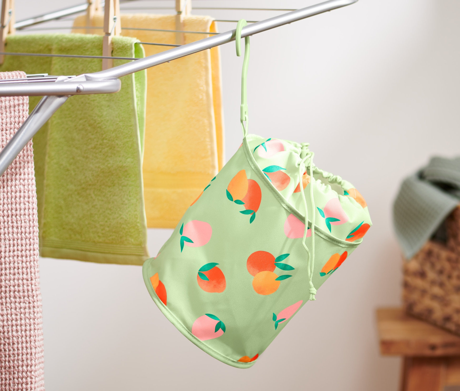 Worek na klamerki wisi na suszarce z ręcznikami.