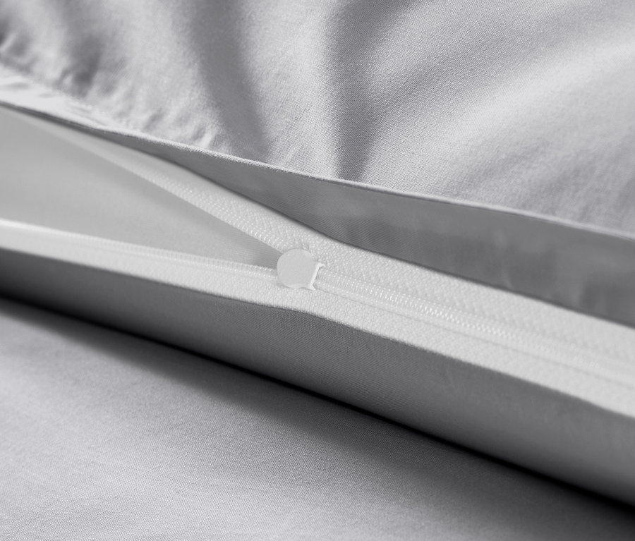 Szczegół szarej pościeli z bawełny satynowej z zamkiem błyskawicznym.