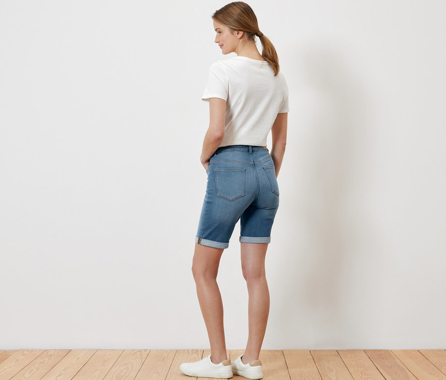 Kobieta pozuje w dżinsach bermudach „Lea” light blue denim.