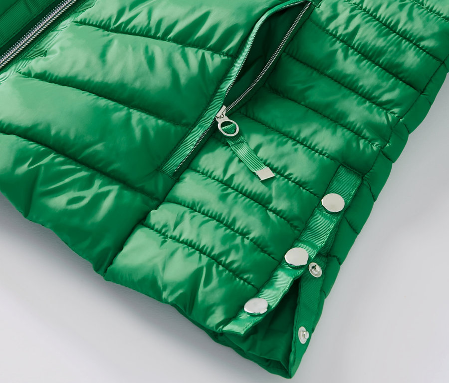 Fragment zielonej pikowanej kurtki.