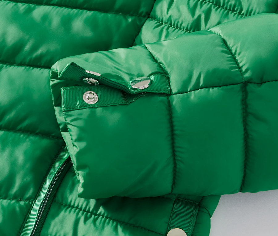 Zbliżenie na zieloną pikowaną kurtkę.