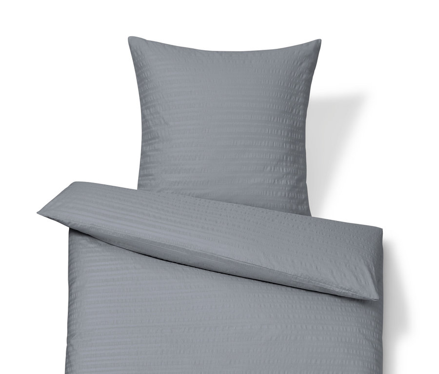 Szara pościel z kory w rozmiarze standardowym i niestandardowym leży na białym tle.