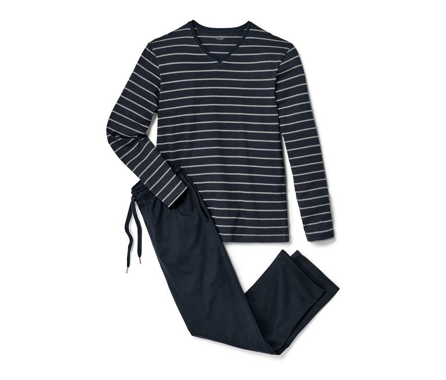 Ciemnoniebieska piżama z długim rękawem i bluzką w paski leży obok granatowych spodni od piżamy.