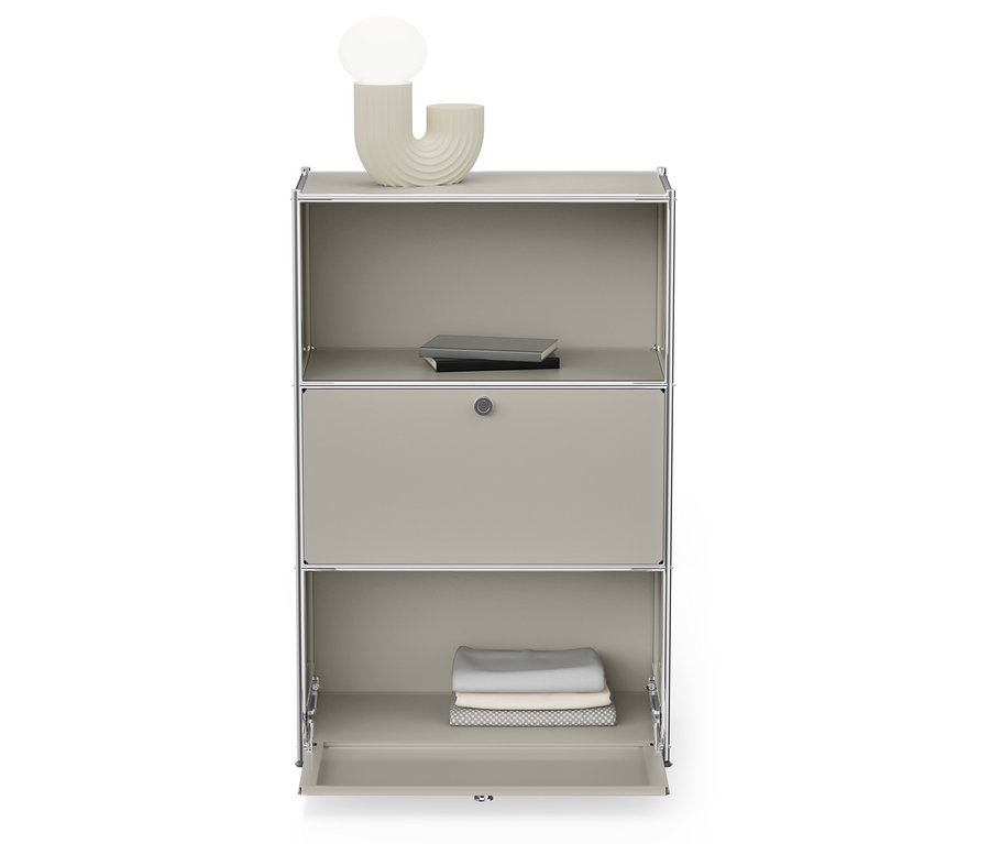 Szara szafka ze srebrną ramą ma otwartą dolną półkę ze złożonymi ubraniami i górną półkę z książkami.