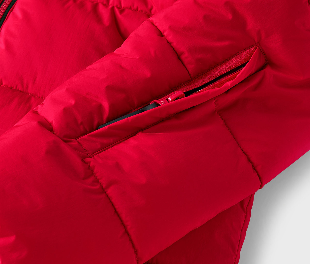 Szczegół czerwonej kurtki puchowej z kieszenią na zamek błyskawiczny.