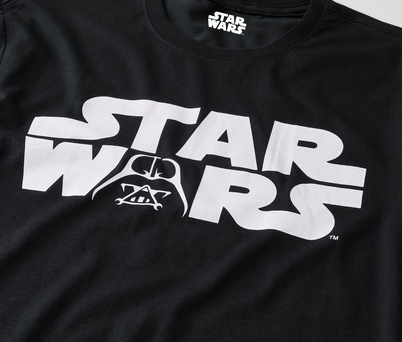 Czarna koszulka z białym logo Star Wars i wizerunkiem Darth Vadera.