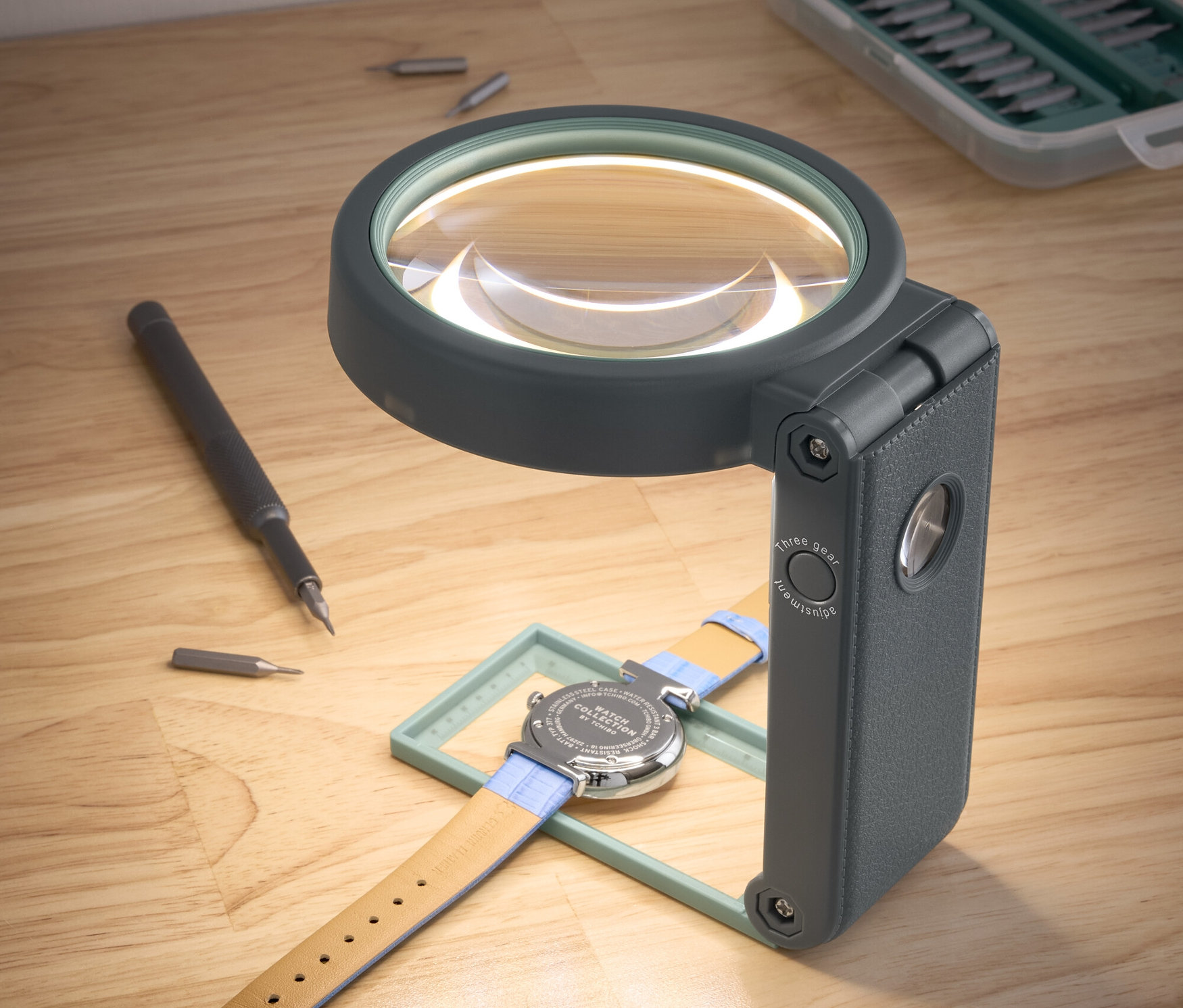 Zegarek leży pod lupą roboczą LED ze stojakiem.