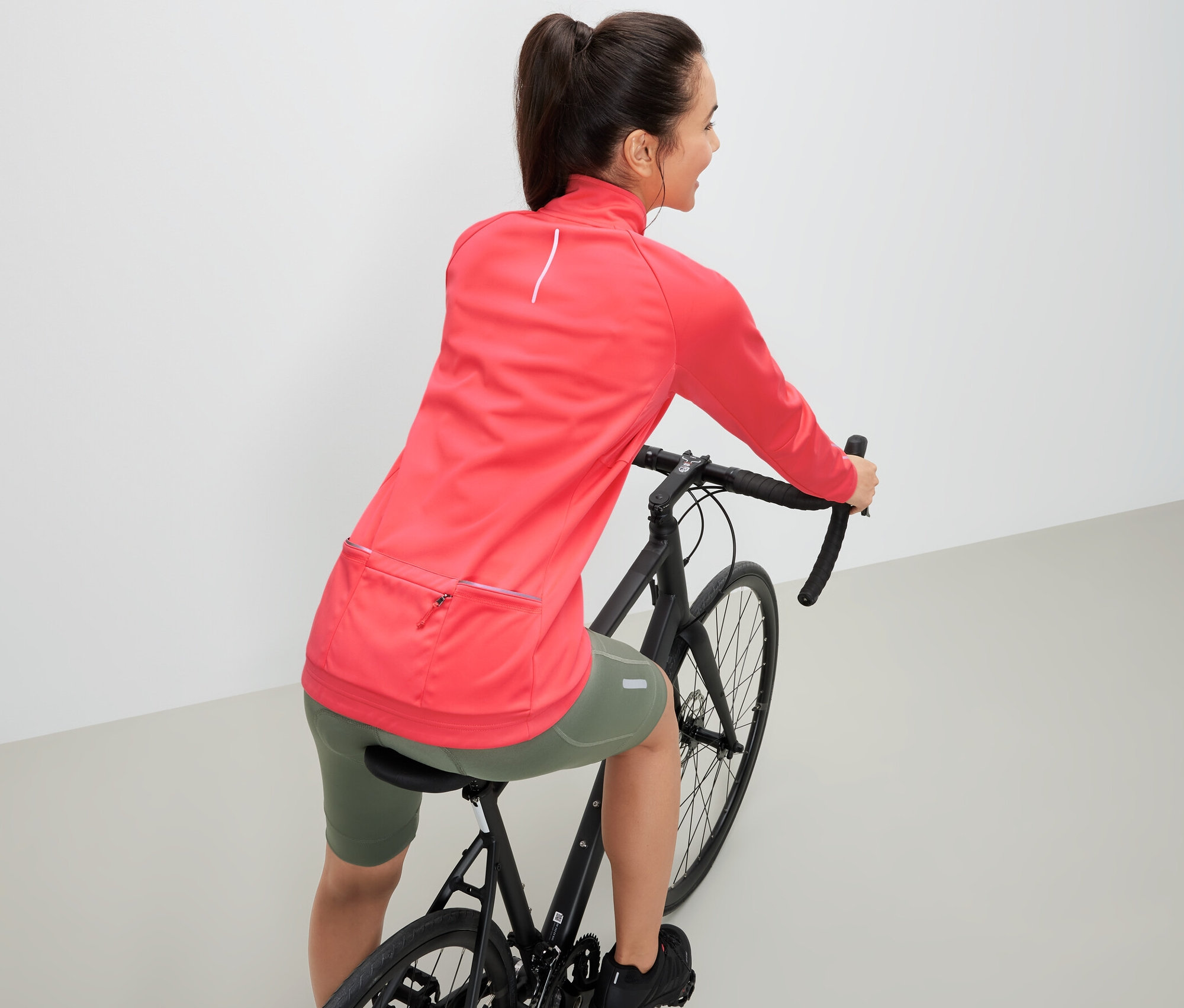 Kobieta na rowerze ma na sobie rowerową kurtkę funkcyjną.