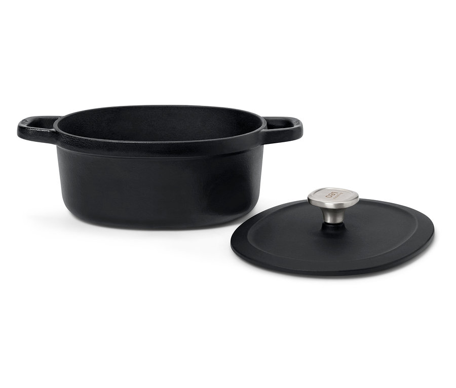 Czarny żeliwny garnek z pokrywką na białym tle.