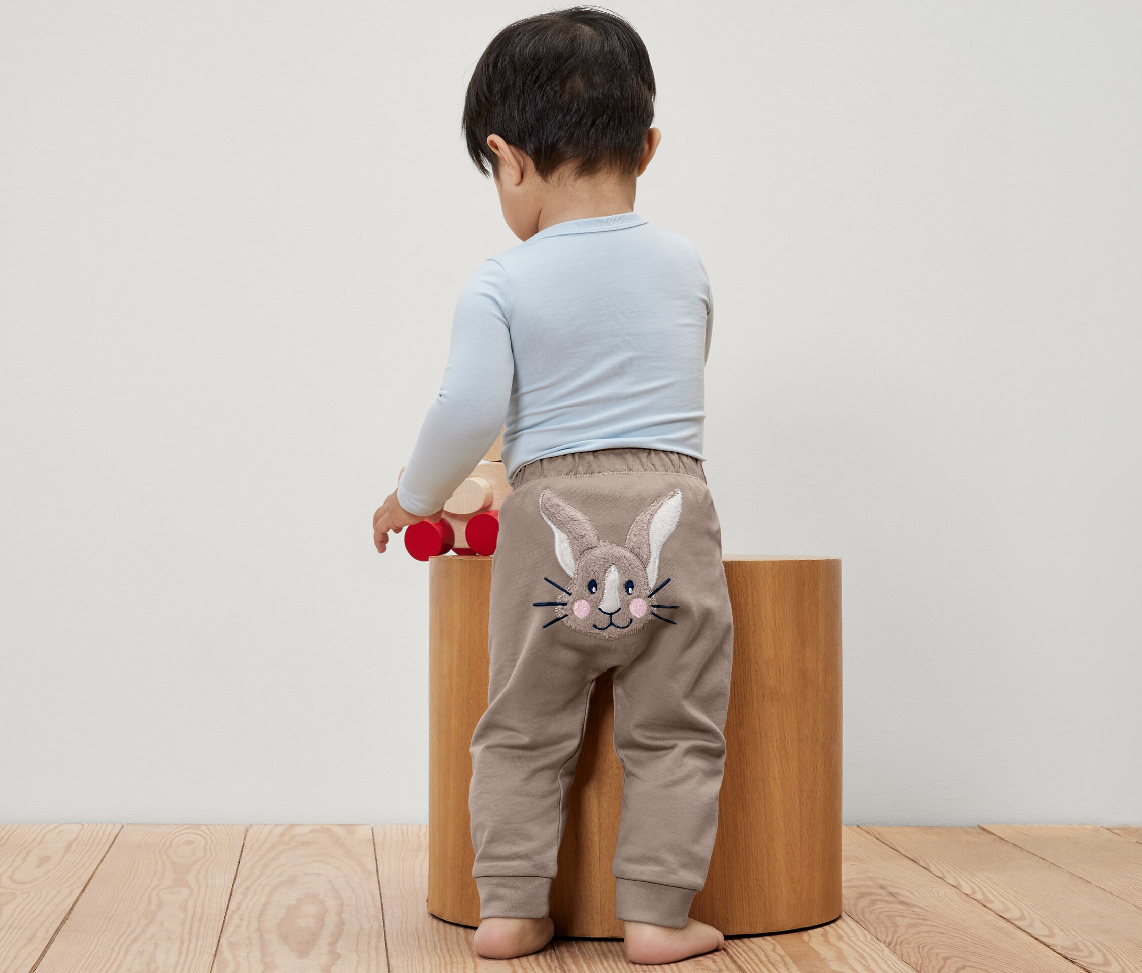 Chłopiec stoi tyłem, ma na sobie spodnie z króliczkiem.