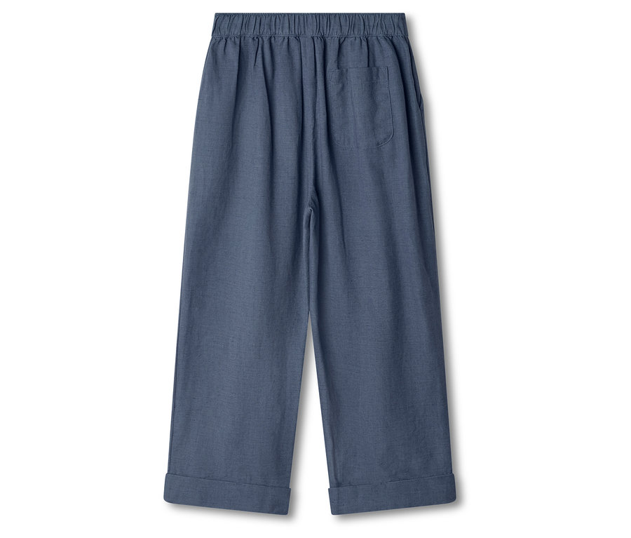 Na białym tle widać niebieskie spodnie.