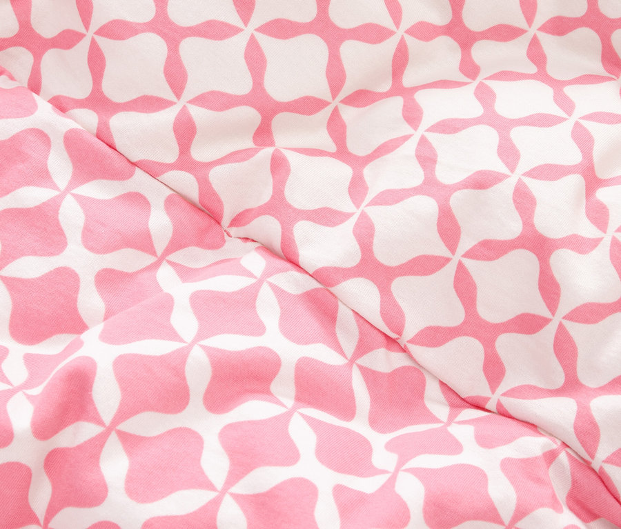 Zbliżenie tkaniny w różowo-biały geometryczny wzór.