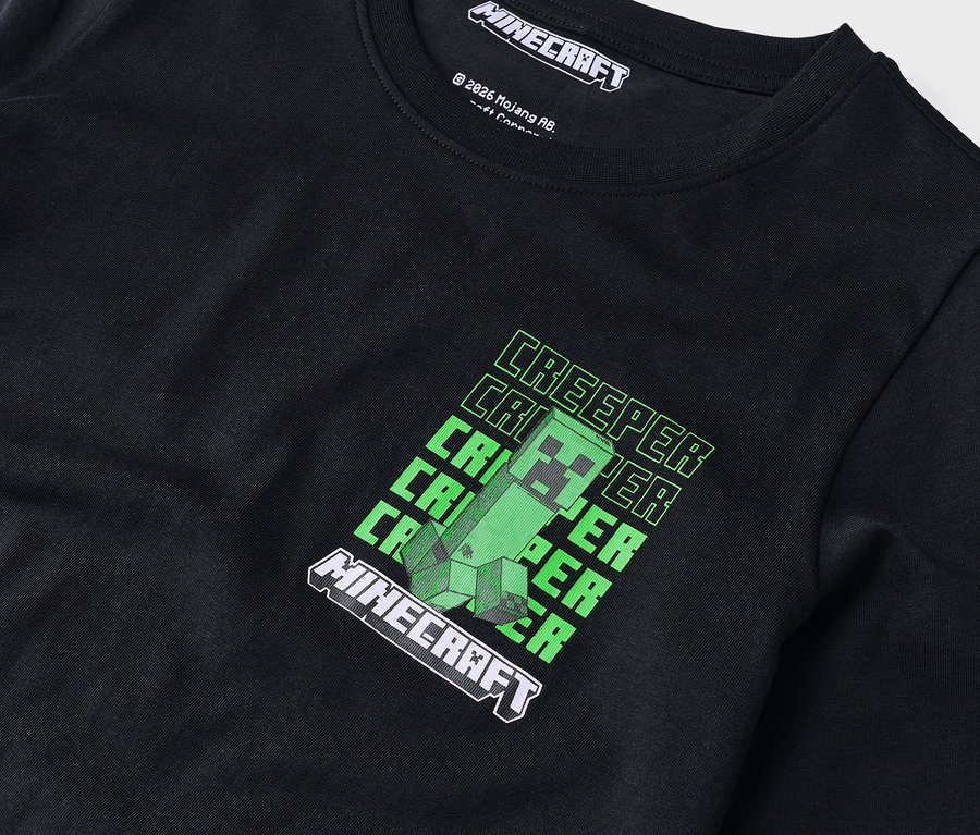 Zbliżenie czarnej koszulki z długim rękawem z zielonym wzorem Minecraft Creeper.