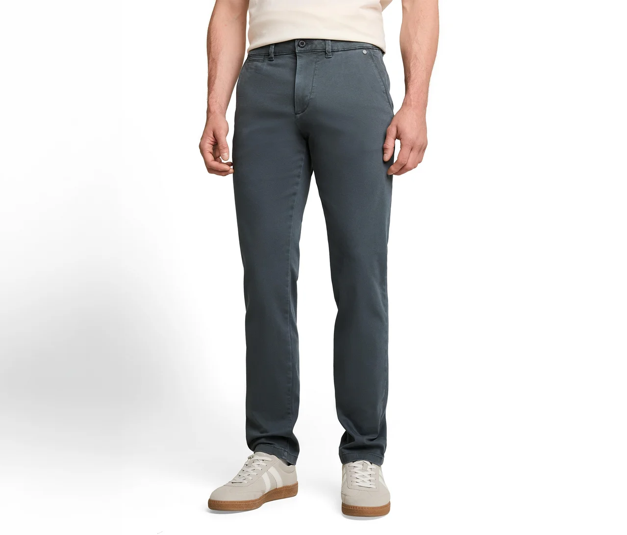 Osoba w ciemnoszarych spodniach chino, jasnym T-shircie i jasnoszarych sneakersach z białymi paskami.