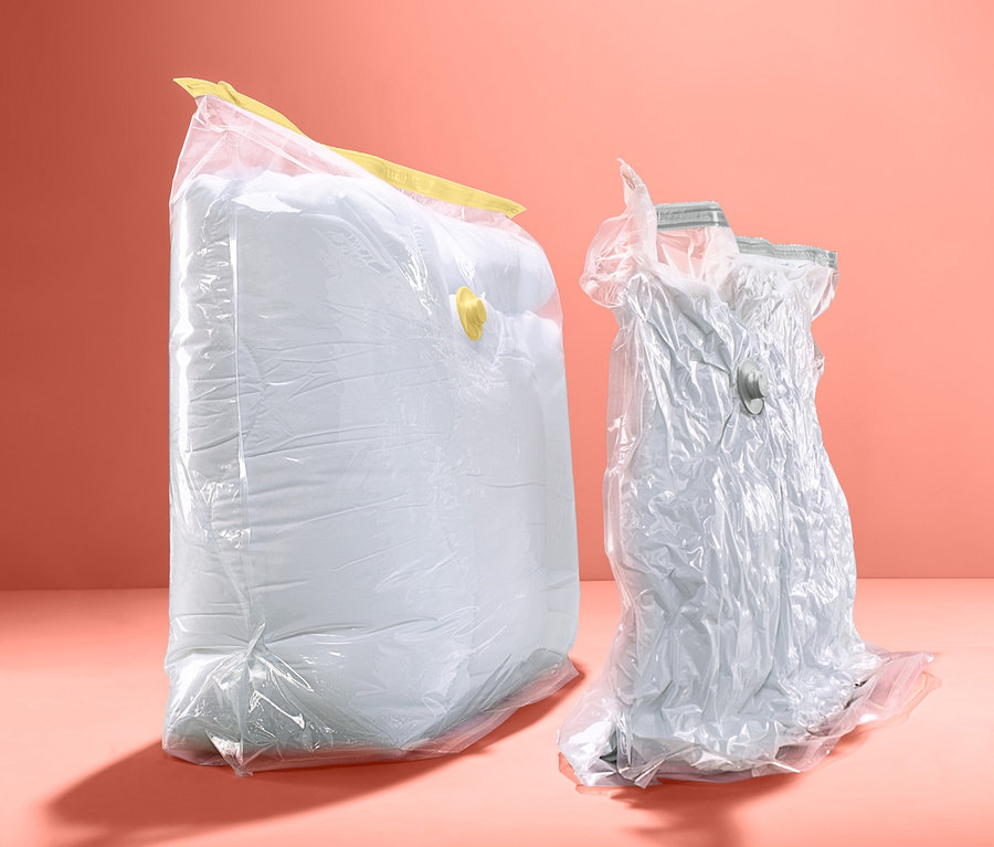 Dwa duże worki próżniowe do przechowywania stoją na koralowym tle.