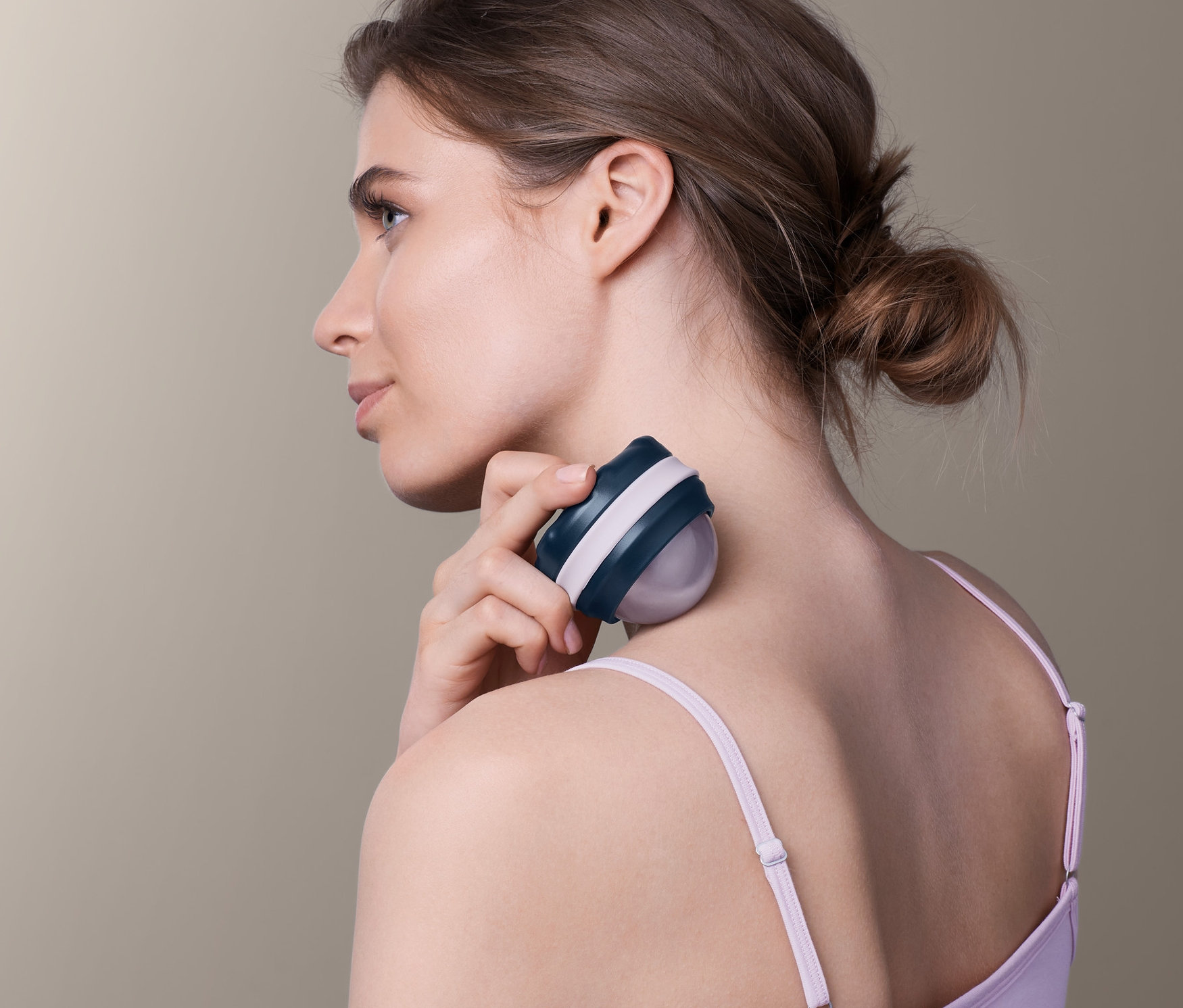 Kobieta używa kuli do masażu na szyi.