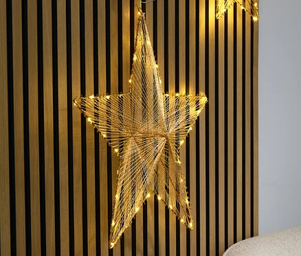 Duża zawieszka-gwiazda LED na tle drewnianych lameli.