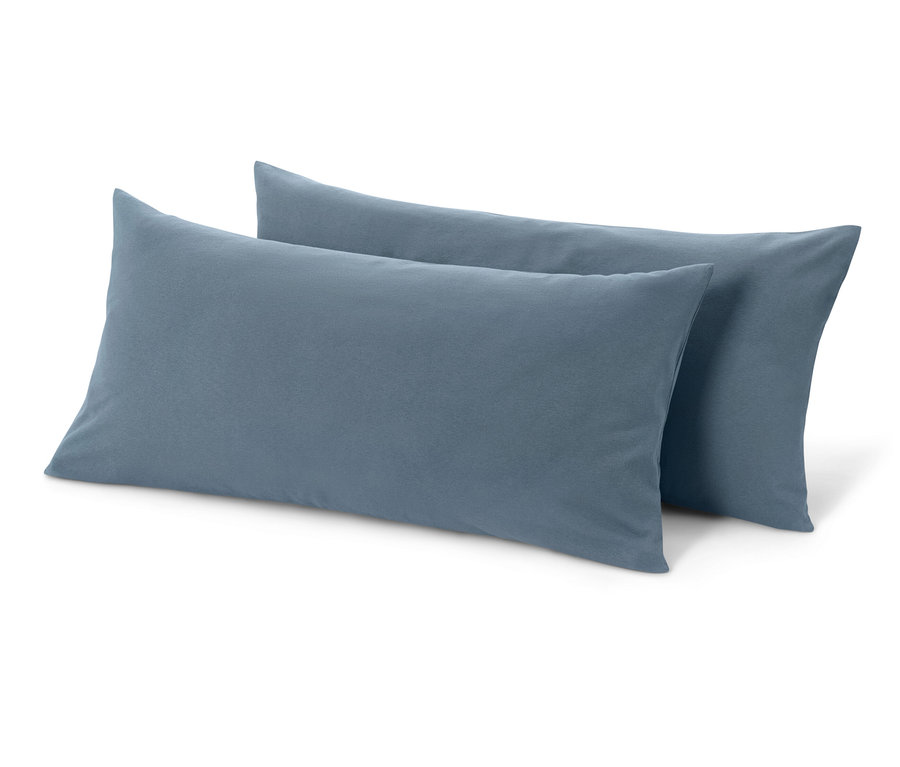 Dwie niebieskie dżersejowe poszewki na poduszki leżą na białym tle.