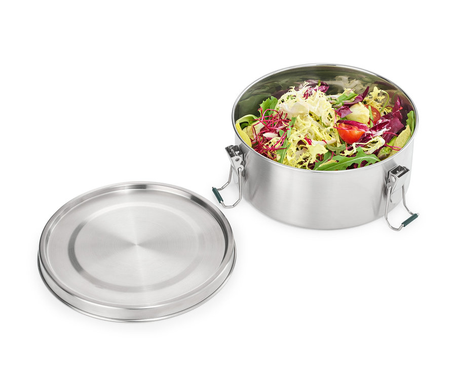 Otwarty pojemnik na lunch ze stali nierdzewnej wypełniony sałatką, obok pokrywka.
