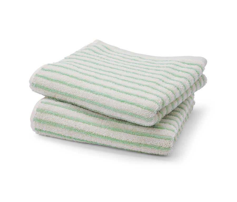 Dwa zielone ręczniki w paski leżą na sobie.