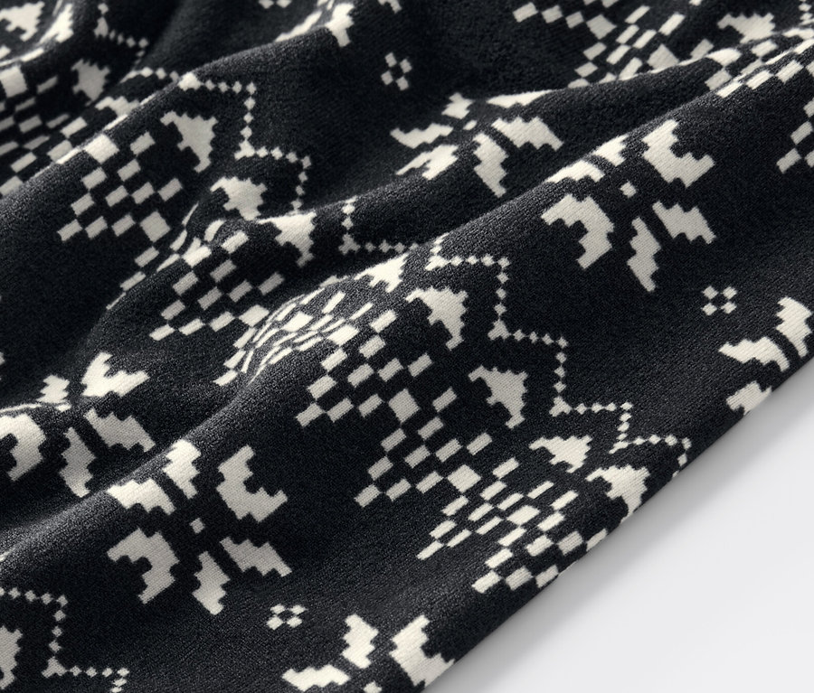 Zbliżenie na czarne legginsy w norweski wzór.