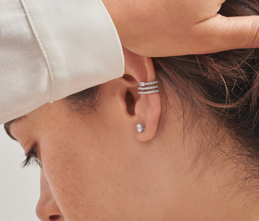Zbliżenie na kobietę noszącą kolczyk na uchu »Ear cuff Spirála«, rodowane srebro próby 925, z cyrkoniami i kolczyki, rodowane srebro próby 925, z cyrkoniami.