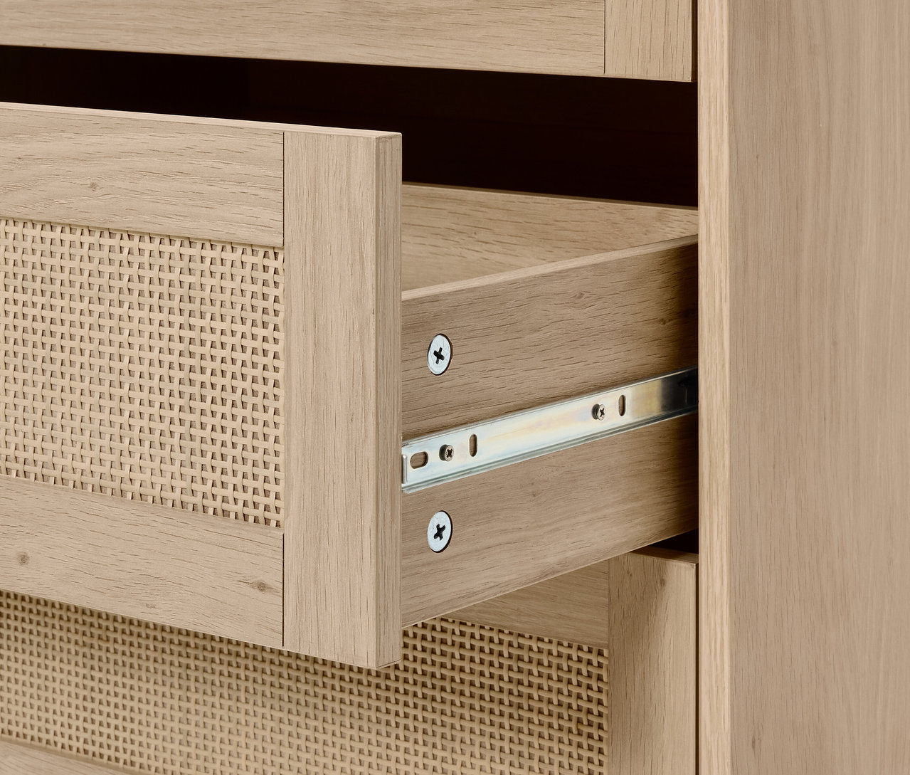 Szczegół komody z otwartą szufladą z wikliny.