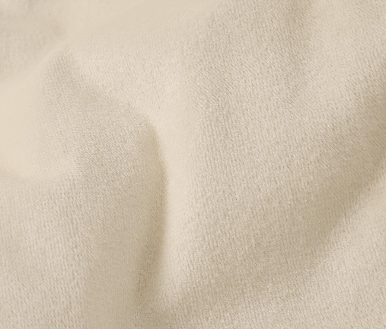 Zbliżenie kremowej tkaniny o delikatnej teksturze i fałdach.