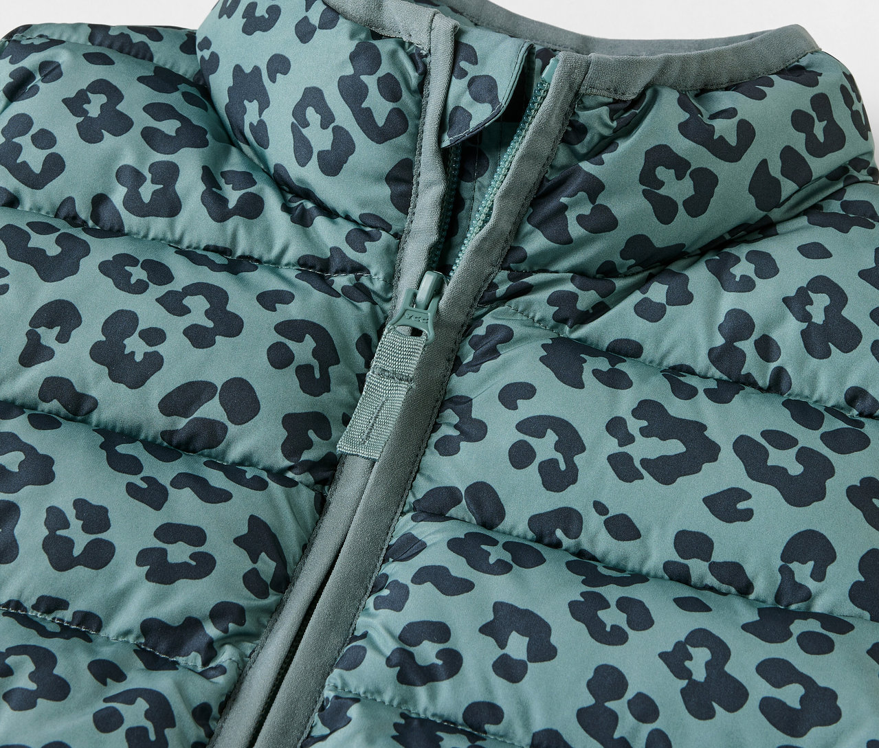 Zbliżenie na kamizelkę pikowaną dla dzieci we wzór zwierzęcy z zamkiem błyskawicznym.