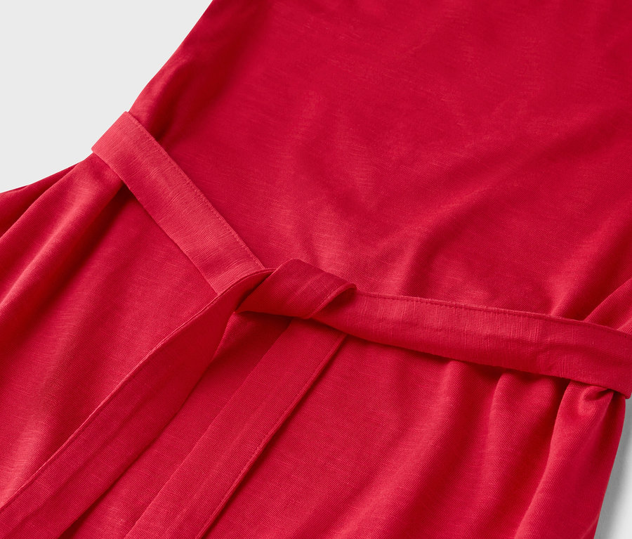 Zbliżenie czerwonej sukienki ze związanym paskiem.