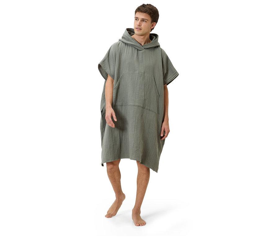 Mężczyzna stoi boso na białym tle, ubrany w oliwkowozielone poncho z kapturem.