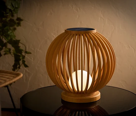 Dekoracyjna lampa solarna z drewna na stole.