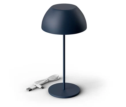 Na białym tle stoi granatowa lampa z kablem USB.