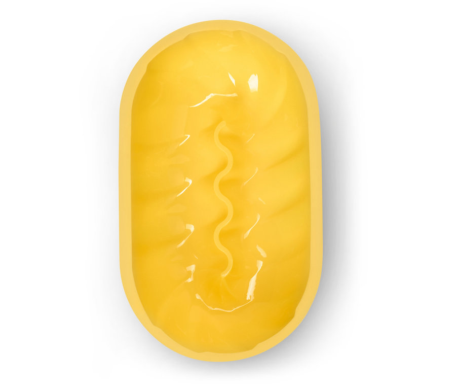 Widok z góry na podłużną, żółtą kulę do kąpieli z pofalowanym rowkiem pośrodku na białym tle.