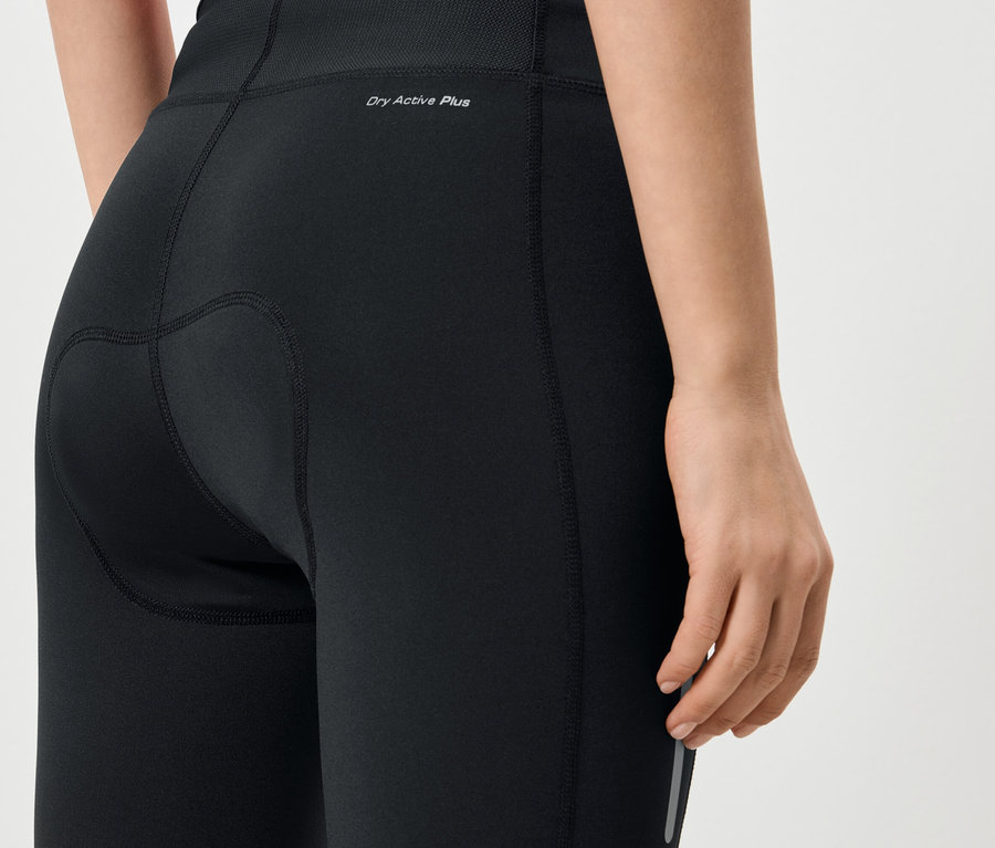Zbliżenie na tył kobiety ubranej w czarne legginsy z napisem „Dry Active Plus”.