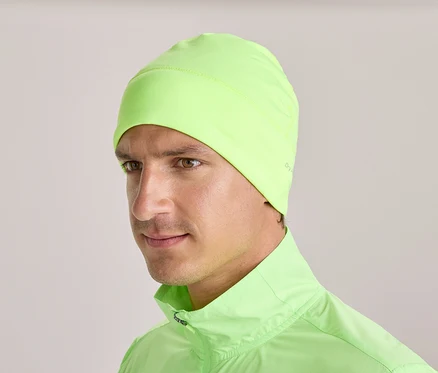 Mężczyzna w neonowo zielonej czapce i pasującej kurtce.
